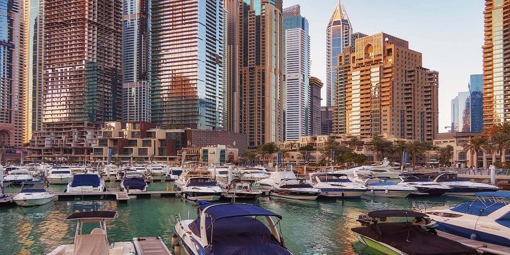 Dubai — a marina of towers at dusk with boats below