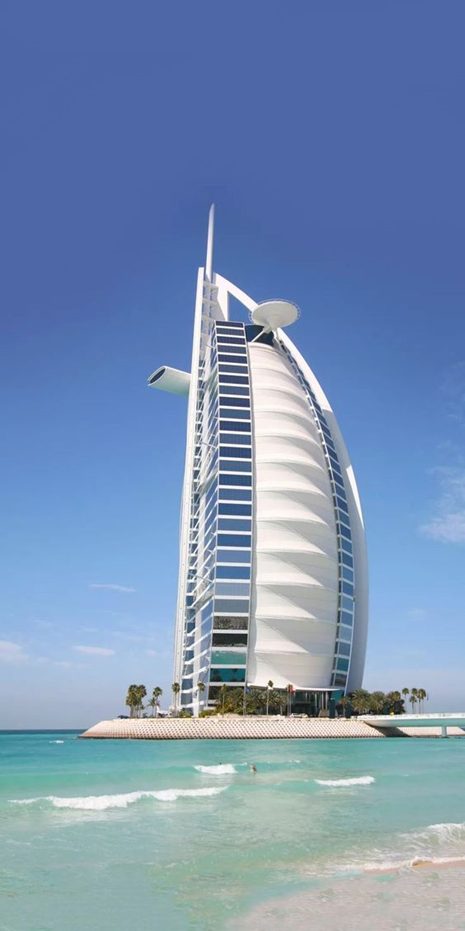 A sail-shaped hotel on its own island, seen from the sea