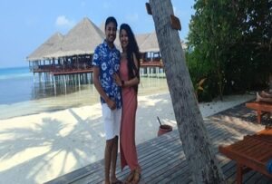 A couple on a jetty by an overwater villa