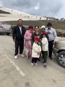 A family group photographed beside a car on a mountain road