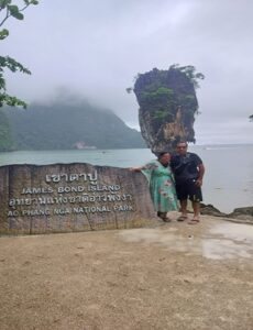 A traveller at a lake viewpoint with a rock islet beyond
