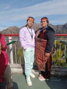 Two guests in shawls photographed against a mountain range
