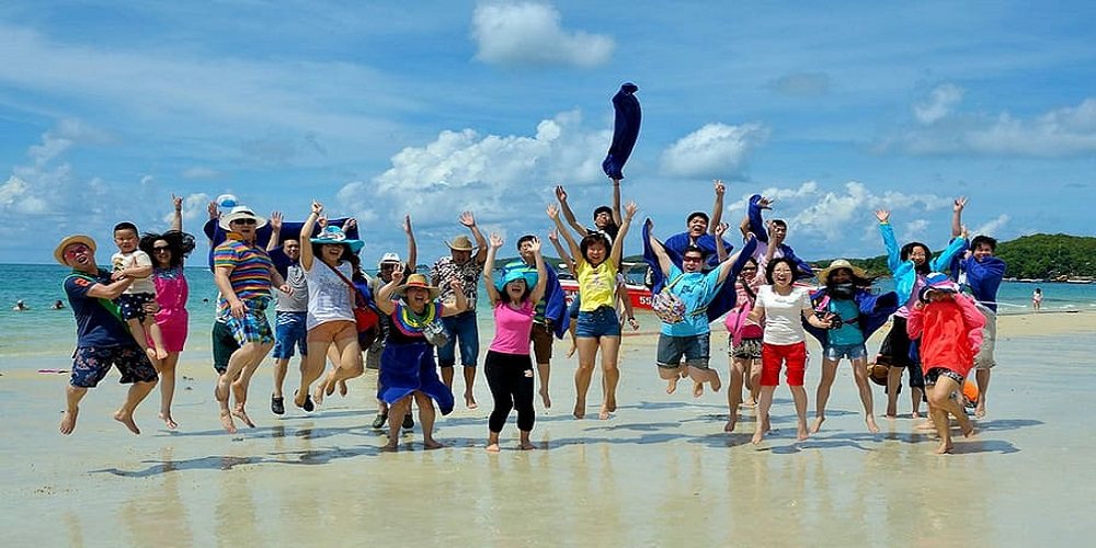 A group cheering on a beach at the start of a holiday